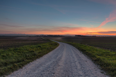 Dusty country road towards the sunset