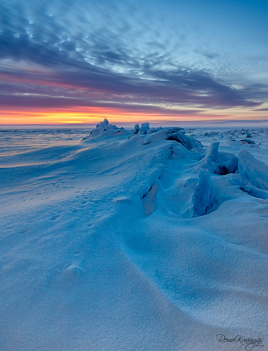 Lumega kaetud jäämurd laisalt looklemas tõusva päikese poole (Peipsi järv)